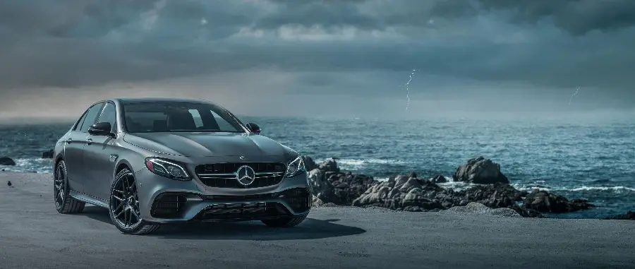 بک گراند مرسدس نقره ای AMG E63 در ساحل دریای طوفانی 