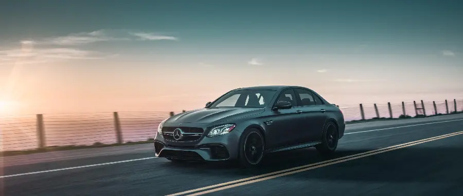 پس زمینه مرسدس بنز مشکی AMG E63 در میان جاده ها 