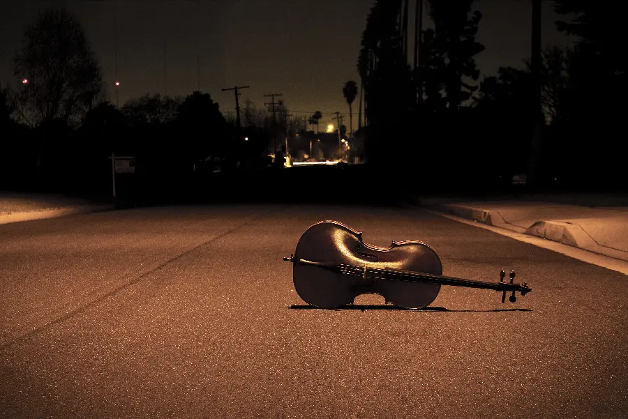 تصویر غمگین ویولن بر زمین افتاده در خیابان تنهایی