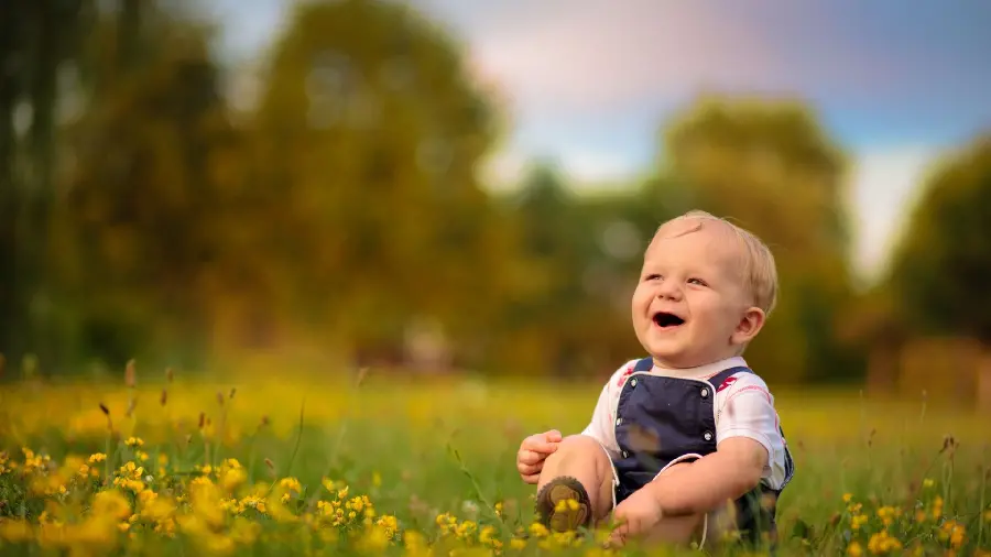 عکس کودک در طبیعت سرسبز بهاری با زمینه مات حرفه ای